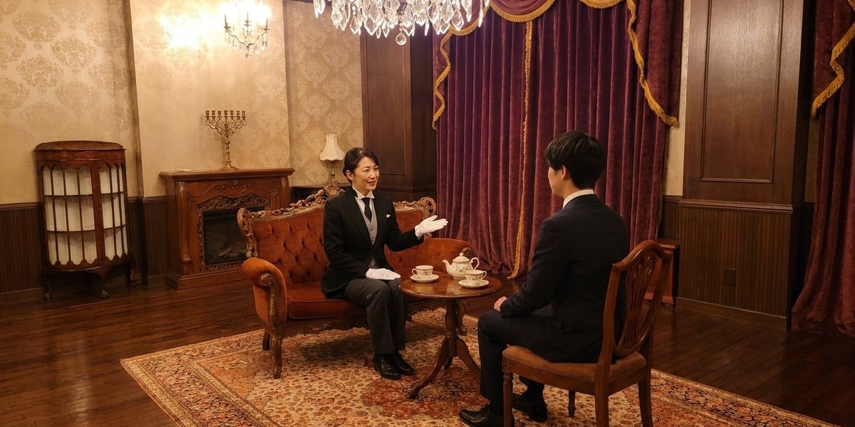 サロンで受講希望者の相談に応じる女性執事